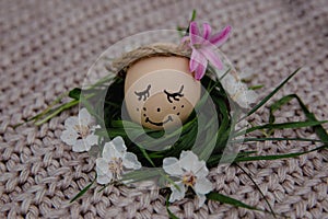 Two eggs with a painted face lie on a scarf