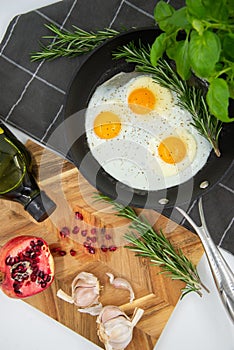 two eggs in a pan on a cutting board next to garlic and peppers