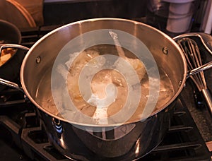 Poaching eggs in plastic bags in boiling water