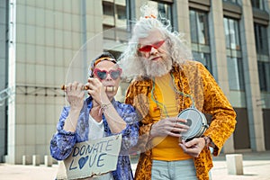 Two elderly hippy men encouraging people for donating love