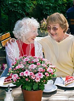 Two elderly ladies enjoying coffee together.