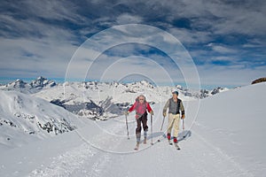 Two elderly men practice ski mountaineering