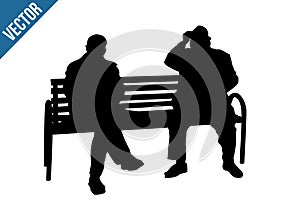 Two elderly people silhouettes sitting on a park bench