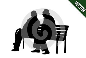 Two elderly people silhouettes sitting on a park bench