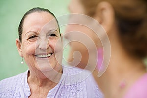 Two elderly women talking on park bench