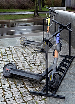 Two electric scooters for city rent are parked on the street.