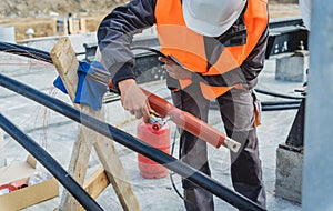 Two electrician builder workers installing high-voltage cable