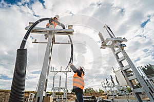 Two electrician builder workers installing high-voltage cable