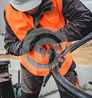 Two electrician builder workers installing high-voltage cable