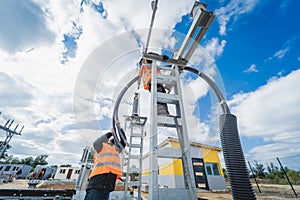 Two electrician builder workers installing high-voltage cable