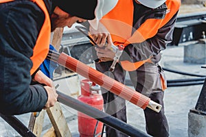 Two electrician builder workers installing high-voltage cable