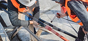 Two electrician builder workers installing high-voltage cable