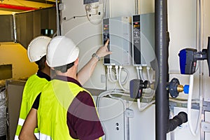 Two electricians checking the power panel