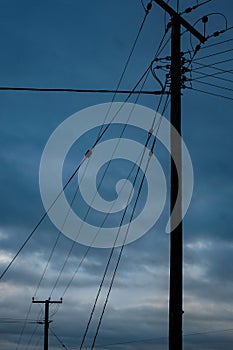 Two electricity pylons silhouetted underneath a cloudy sky