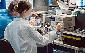 Two electronic engineers on the test bench measuring a new product