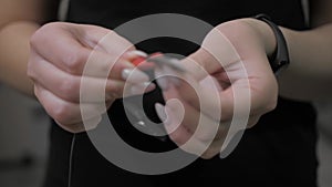 Two electronic sensors on a female hand, red and black