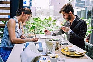 Two elegant business partners working together on project in cafe