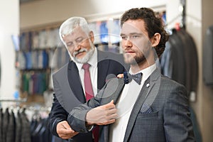 Two elegant men coming to fashion boutique on shopping.