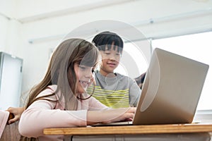 Two Elementary school kids using laptop