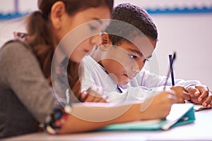 Two elementary school pupils working at desk during a lesson