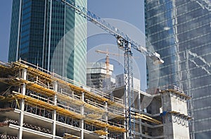 Two elevating cranes on a construction site