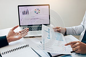 Two employees check the financial statements of the company together in the accounting room photo