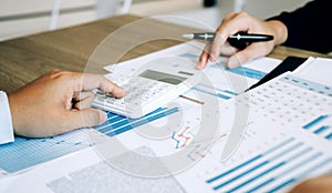 Two employees check the financial statements of the company together in the accounting room photo