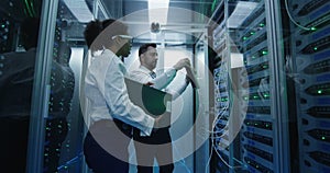 Two employees performing maintenance in a data center