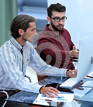 Two employees , sitting in front of computer