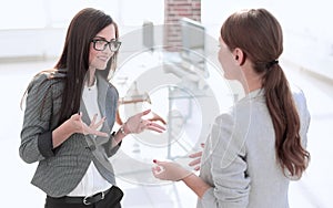 Two employees talking standing in the office