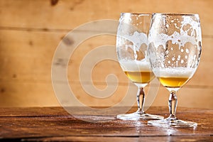 Two emptied glasses of beer on a counter