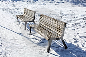 Two empty benches on snow covered