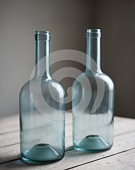 Two empty blue bottles sitting on top of a table.
