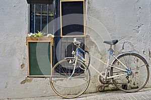 Two empty bulletin boards hanging on a wall next to an old bicycle