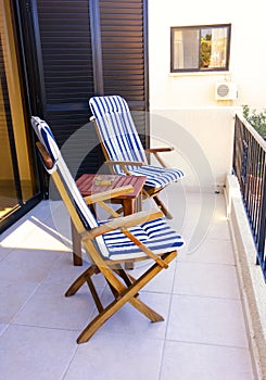 Two empty chairs with table on balcony