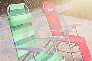 Two empty deck chairs at the pool