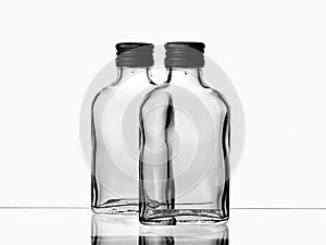 Two empty glass russian vodka bottle with black cap isolated on a white background