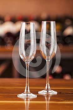 Two empty glasses in background with bottles of wine