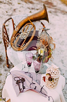 Two empty glasses of bride and groom on decorated table in wedding area. Wedding decoration.