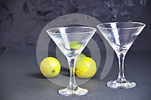 Two empty glasses for making margarita cocktails with lime on a black background Margarita cocktails shot on a bar