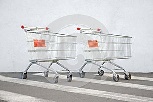 Two Empty Grocery Cart on the White Wall Store. Trolley at the Supermarket Background. E-commerce. Shopping Online. Side