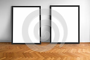 Two empty picture frames on wooden parquet floor white wall background , blank frame