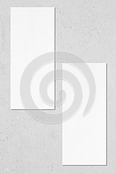 Two empty price-list or menu mockups lying on grey concrete background