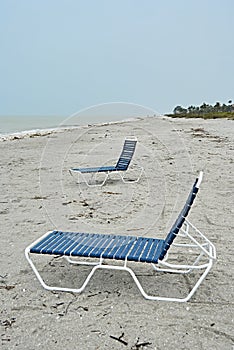 Two empty sun loungers at empty beach