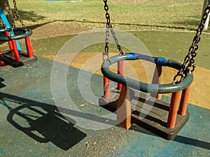 Two empty swings in park on fall morning