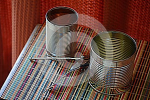 Two empty tin cans with an opener.