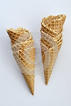 Two empty waffle cones on white background
