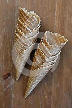 Two empty waffle cones on a wooden table