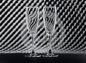 Two empty wine glasses on an abstract background.