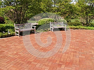 Two empty wood benches by a red patio photo